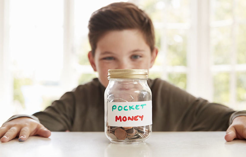 little boy looking at a jar of pocket money