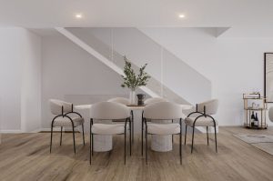 wooden flooring, white and grey marble dining table, white and glass staircase leading upstairs