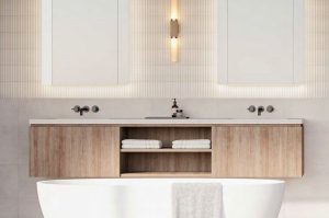 white bathtub in front of 2 white counter sinks, brown cabinets and two mirrors